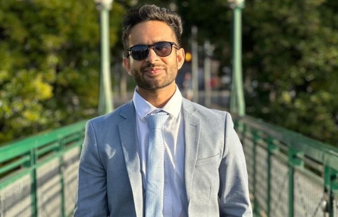 Man standing in a suit in front of trees